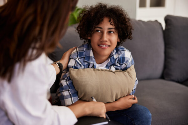 Teenager get reassured while having a consultation with mental healthcare professional.